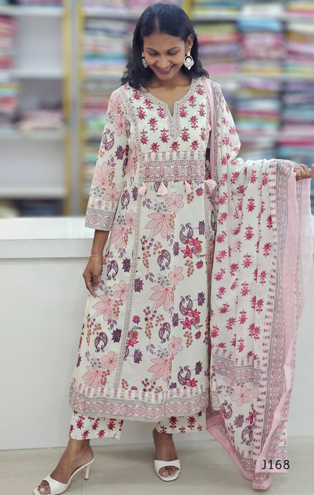 Woman wearing a floral dress with a matching dupatta in a store setting