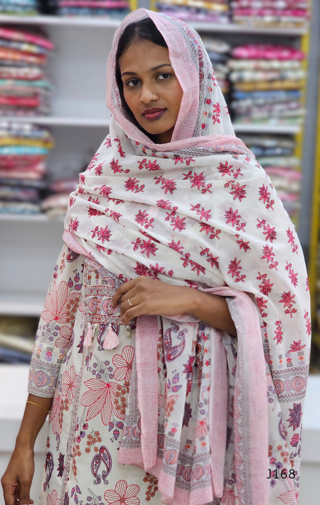 Woman wearing a floral shawl in a fabric store