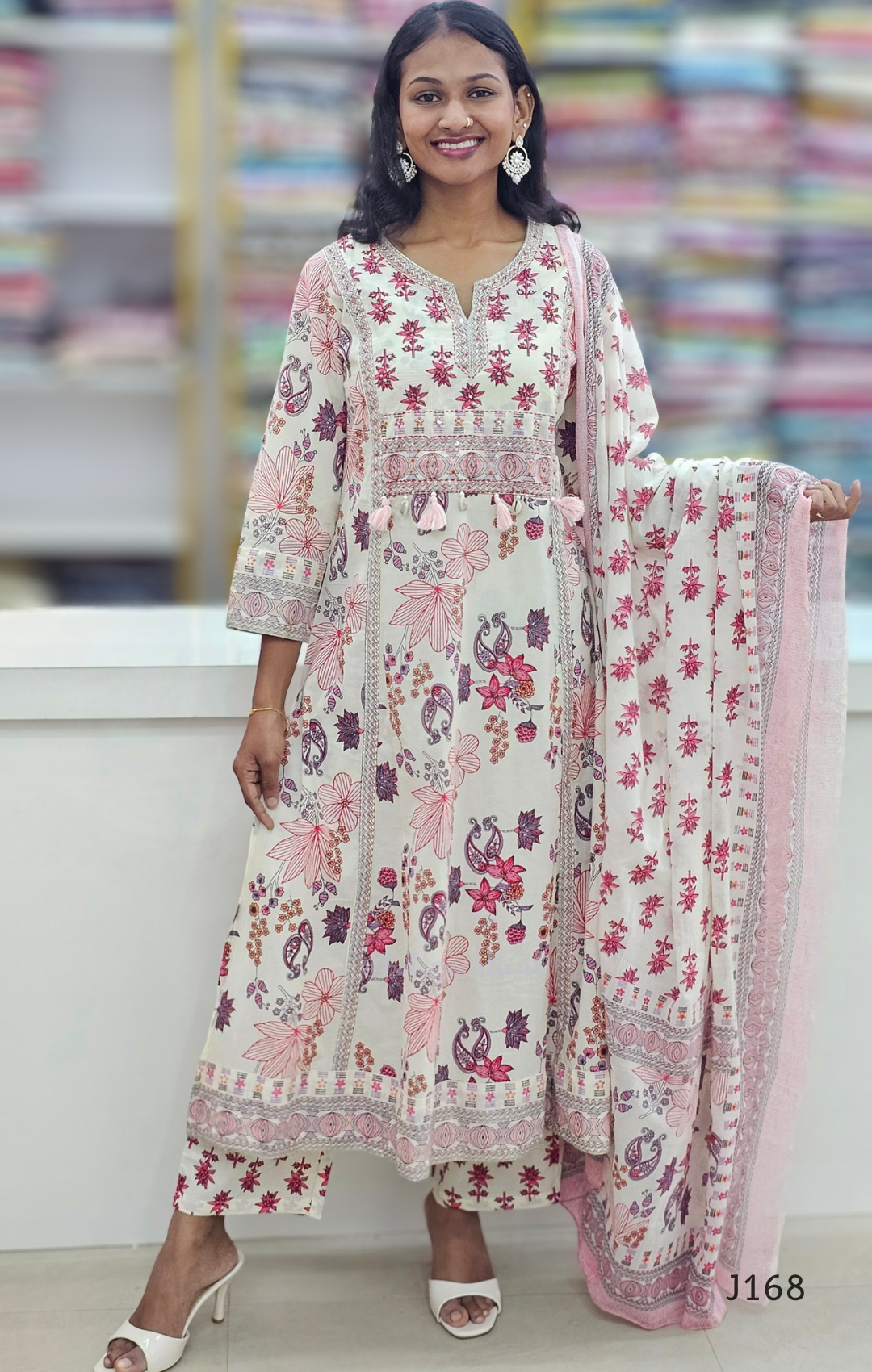 Woman wearing a floral dress with a matching dupatta in a store setting
