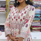 Woman wearing a floral patterned dress with a blurred store background
