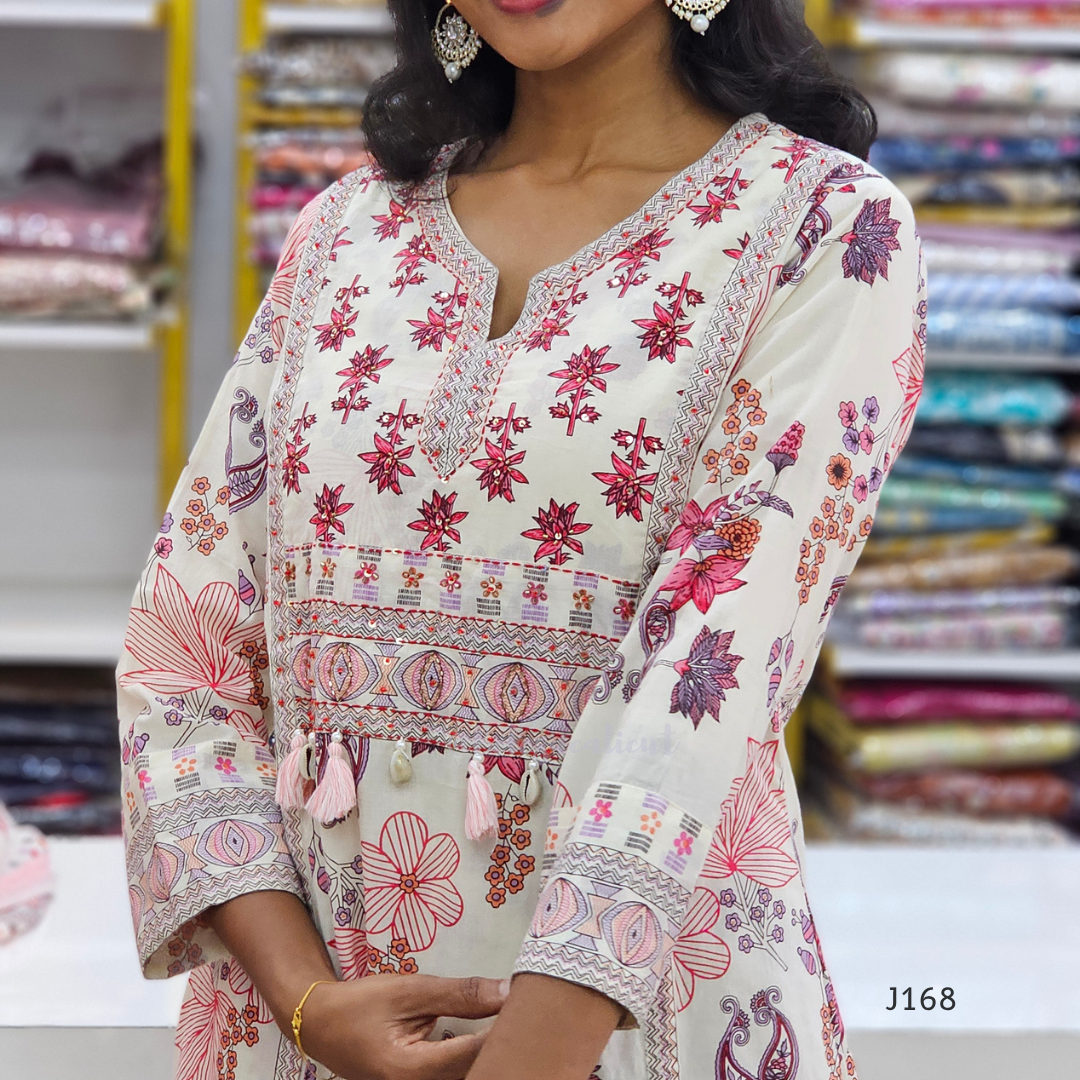 Woman wearing a floral patterned dress with a blurred store background