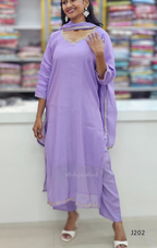 Woman wearing a purple traditional outfit with a matching dupatta in a store setting.