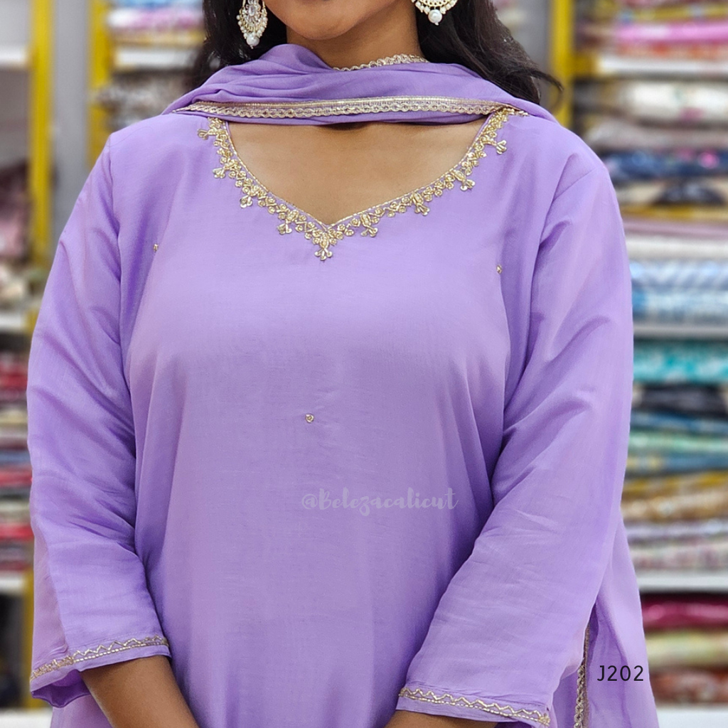 Woman wearing a purple outfit with gold embroidery in a store setting