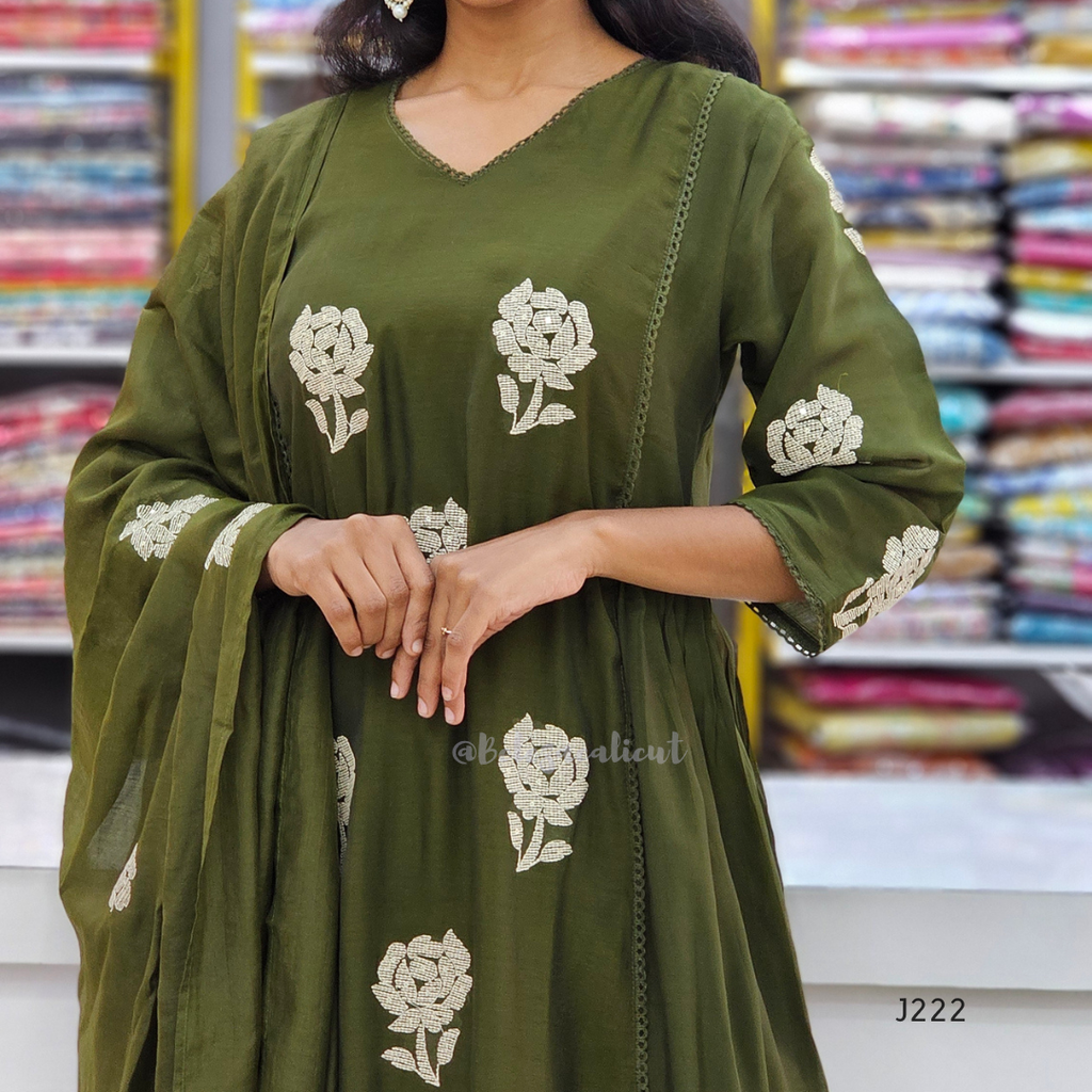 Green dress with floral embroidery in a store setting