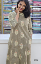 Woman wearing a long, patterned dress with a blurred fabric store background