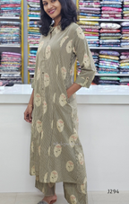 Woman wearing a green and white patterned kurta with pants in a fabric store.