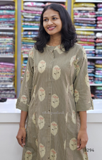 Woman wearing a floral-patterned kurta in front of fabric shelves