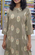 Woman wearing a floral and striped dress in a fabric store.