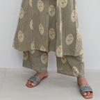 Person wearing a layered outfit with floral and striped patterns on a white background