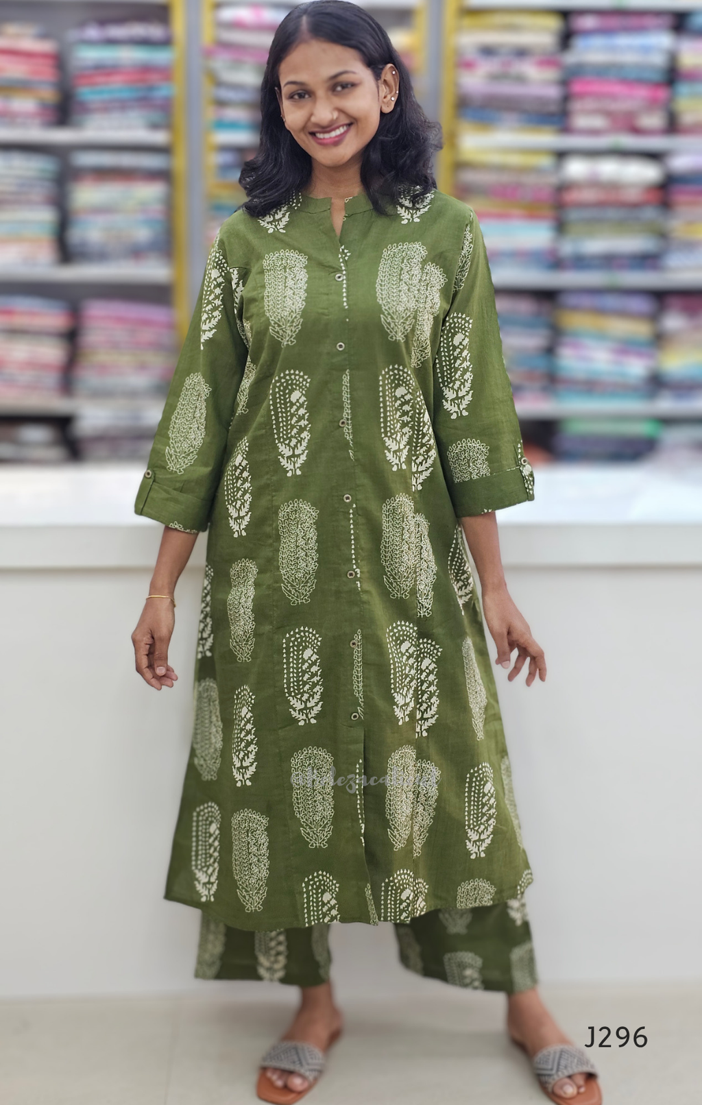 Woman wearing a green patterned kurta with palazzo pants in a fabric store.