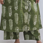 Green skirt with white pattern worn by a person on a plain background