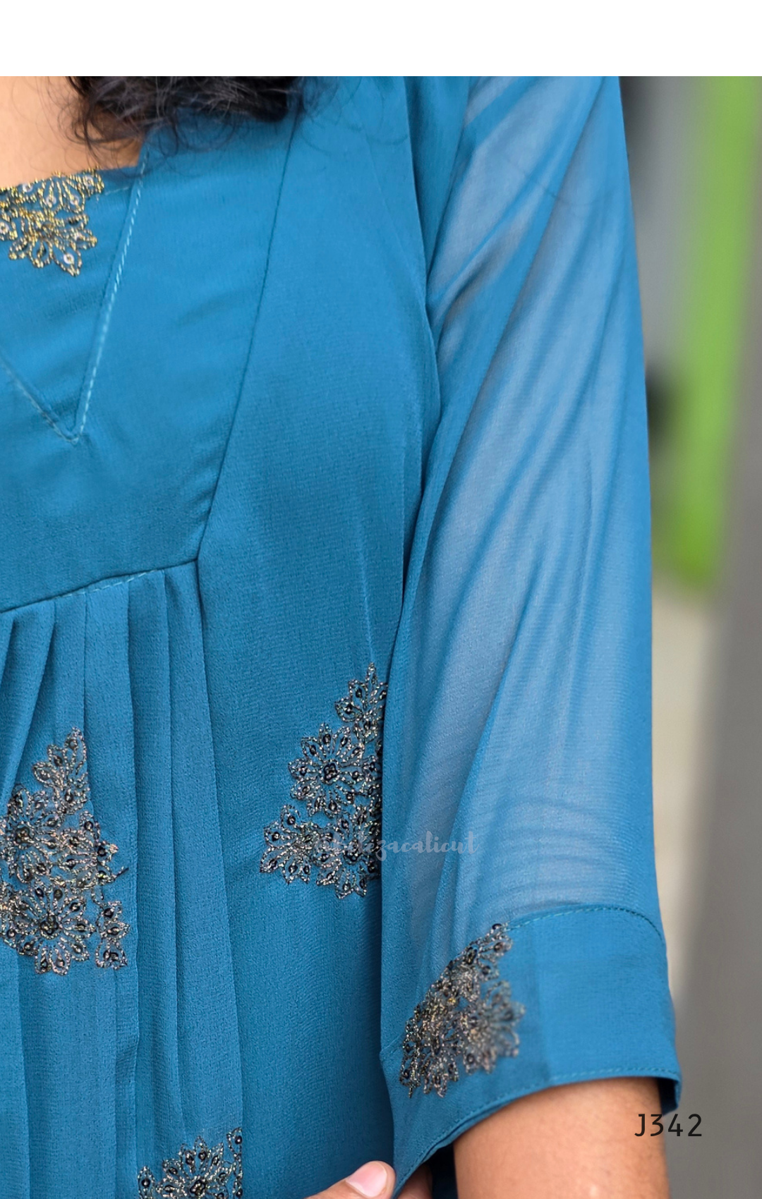 Blue dress with floral embroidery on a blurred background