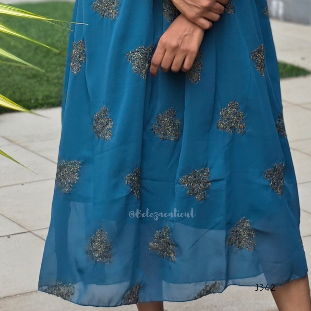 Blue dress with silver floral patterns on a blurred outdoor background