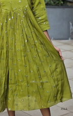 Green dress with floral patterns on a neutral background