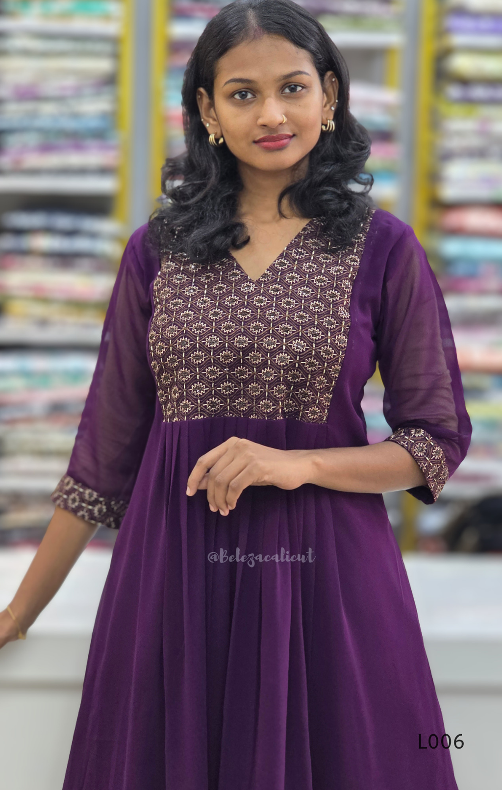 Woman wearing a purple dress with intricate patterns in a store setting