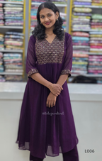 Woman wearing a purple outfit with a patterned top in a fabric store.