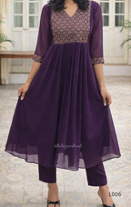 Woman wearing a purple outfit with a patterned top in an indoor setting