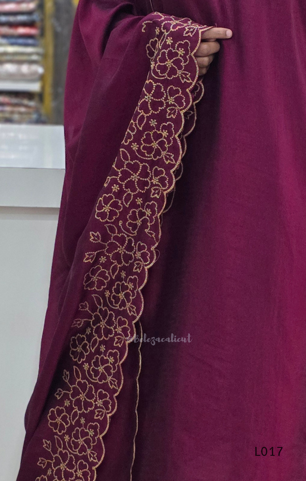 Mauve abaya with intricate gold embroidery on a blurred background