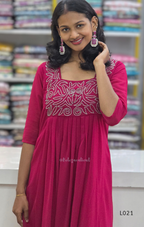 Woman wearing a pink traditional outfit with intricate designs in a store setting