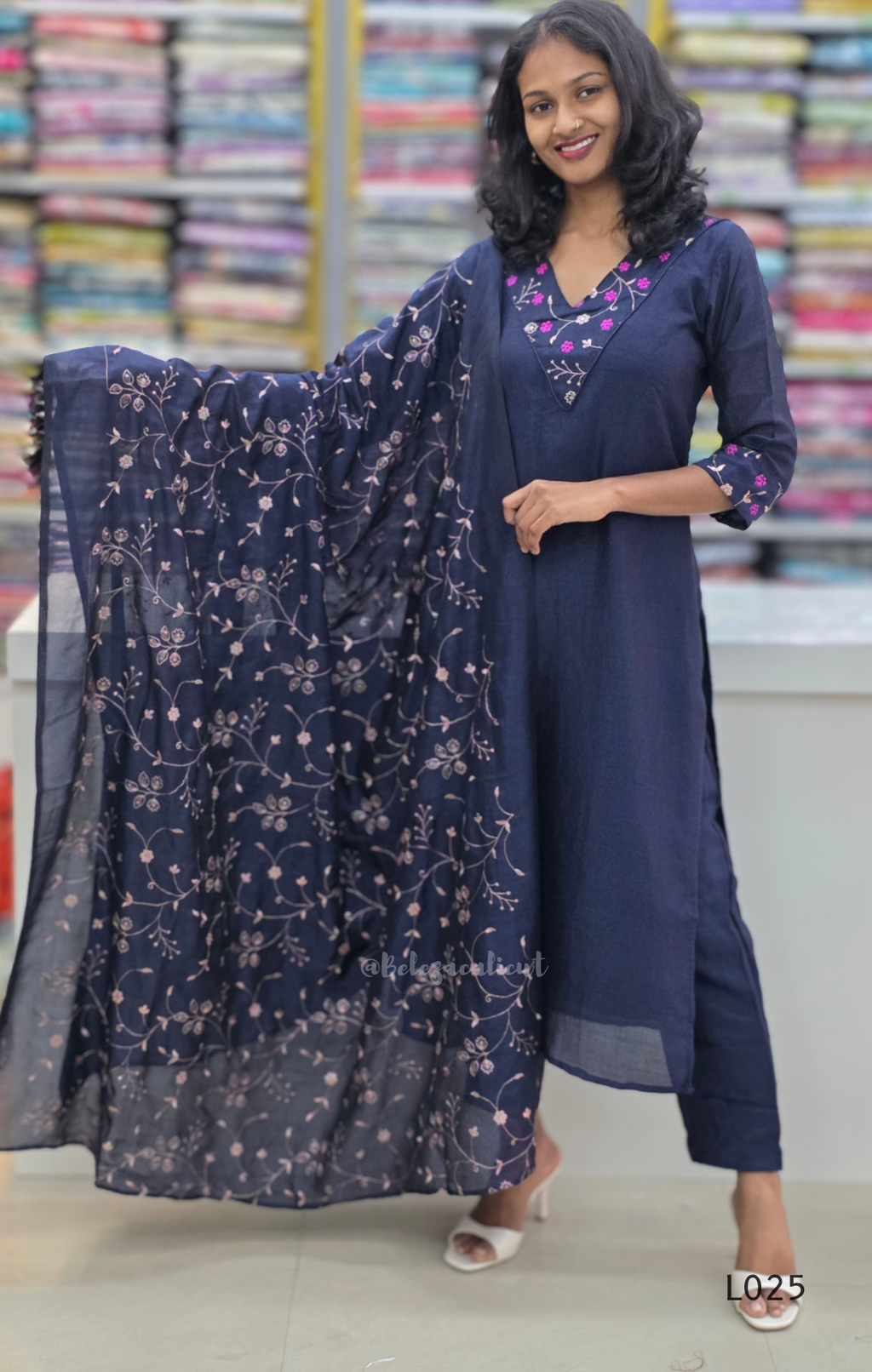 Woman wearing a navy blue kurta with a matching dupatta in a fabric store.