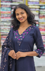Woman wearing a navy blue outfit with floral patterns in front of a colorful background