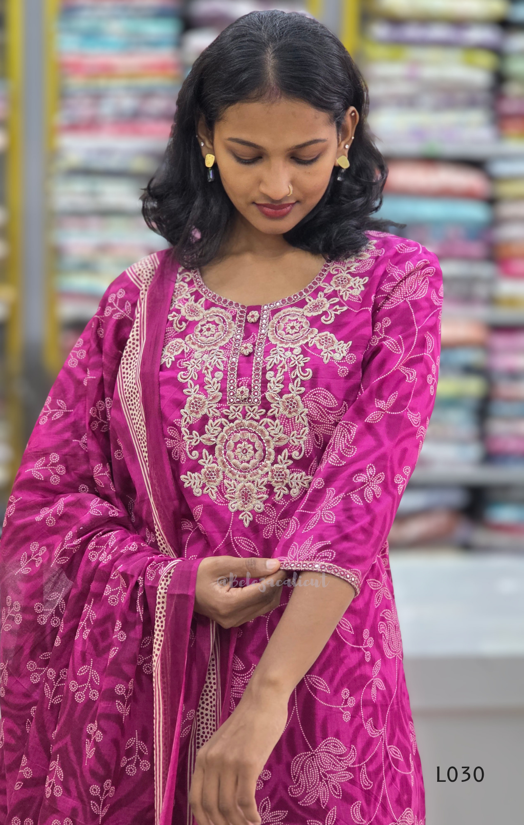 Woman wearing a pink embroidered traditional outfit with a blurred background
