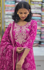 Woman wearing a pink embroidered traditional outfit with a blurred background