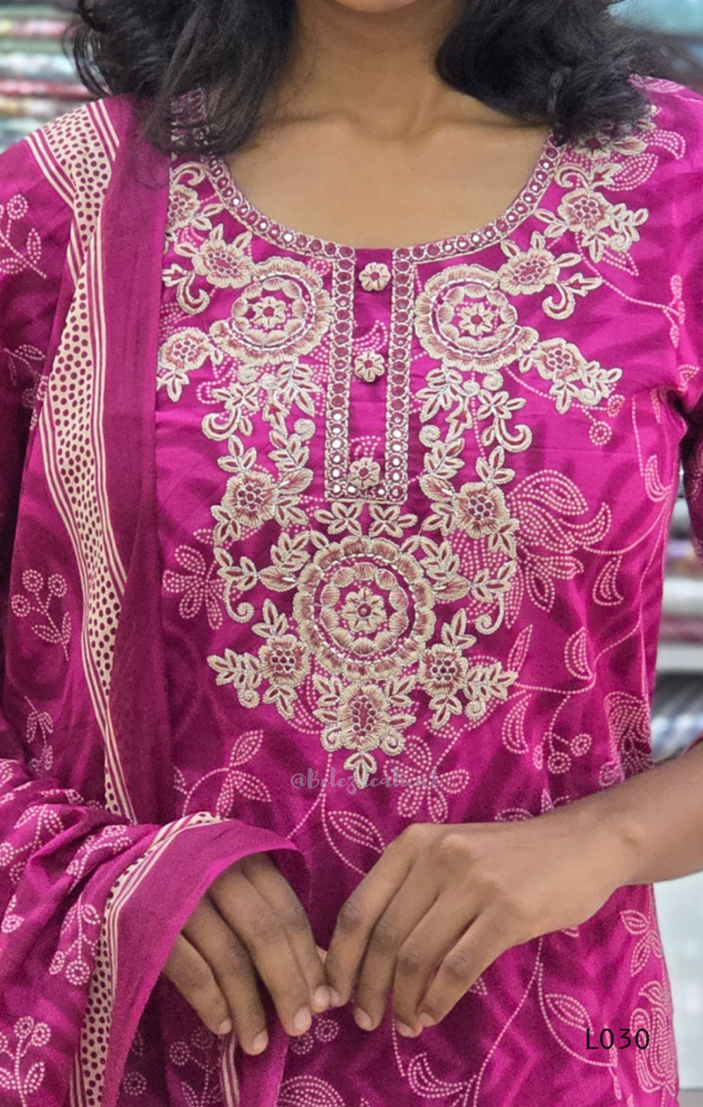 Close-up of a pink embroidered traditional outfit with intricate patterns.