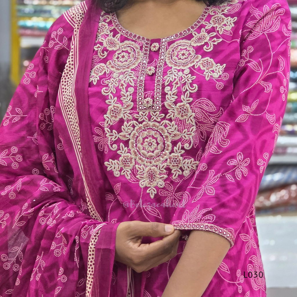 Close-up of a pink embroidered traditional outfit with intricate patterns.
