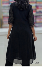 Black dress with patterned cuffs worn by a person, blurred background