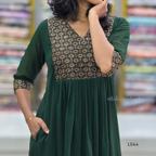 Green dress with patterned neckline worn by a person, blurred background
