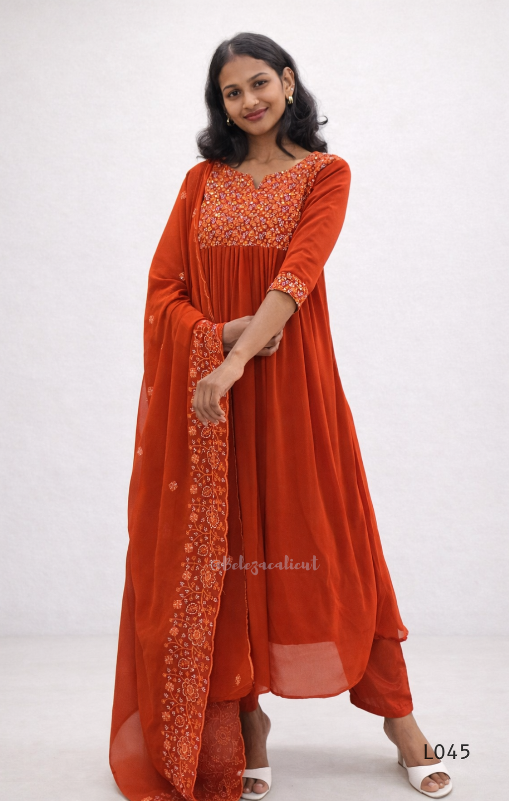 Woman wearing an orange traditional outfit with a white background
