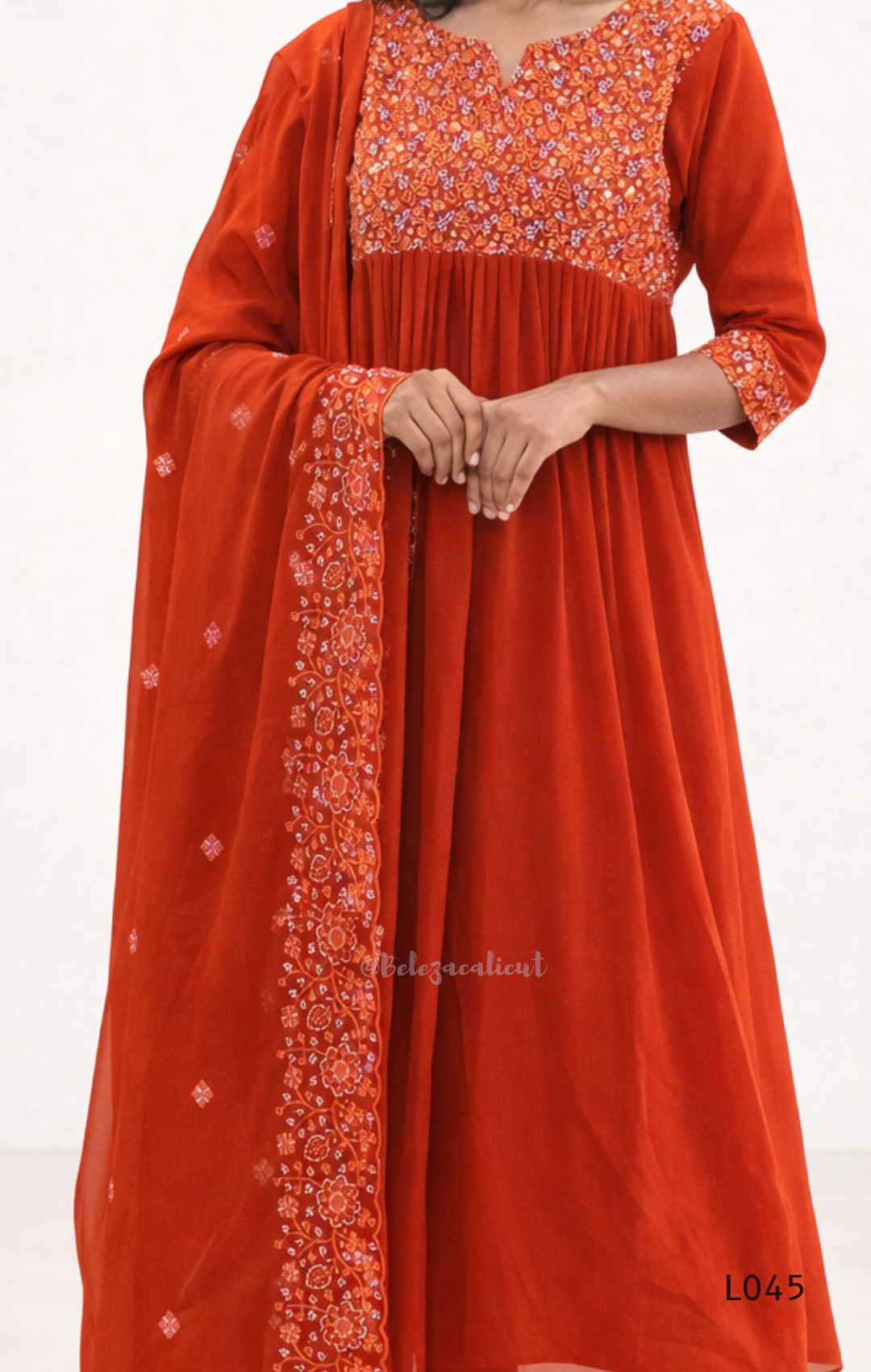 Orange traditional outfit with floral patterns on a white background