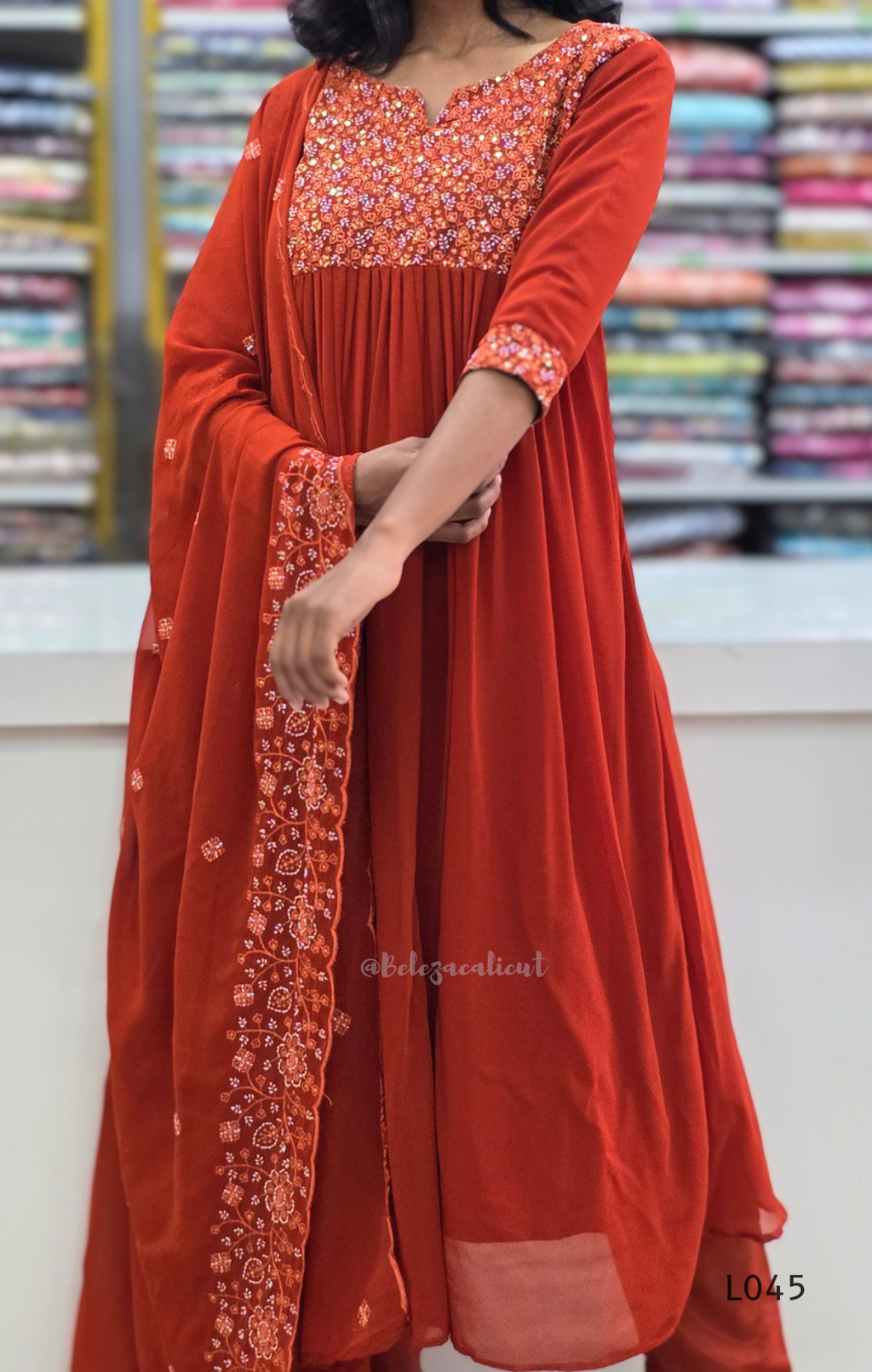 Red traditional outfit with floral patterns in a store setting