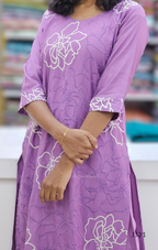Purple dress with white floral patterns worn by a person, blurred background