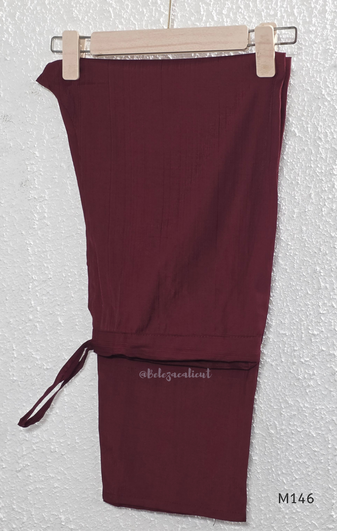 Deep maroon Vertigan silk co-ord set with pleated A-line top, gold circular side motifs and matching straight pants.