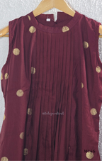 Deep maroon Vertigan silk co-ord set with pleated A-line top, gold circular side motifs and matching straight pants.