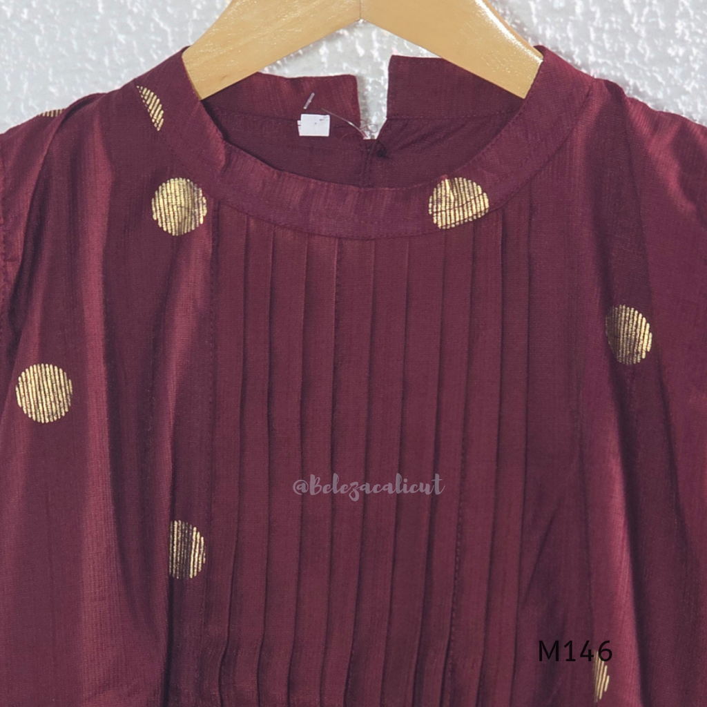 Deep maroon Vertigan silk co-ord set with pleated A-line top, gold circular side motifs and matching straight pants.