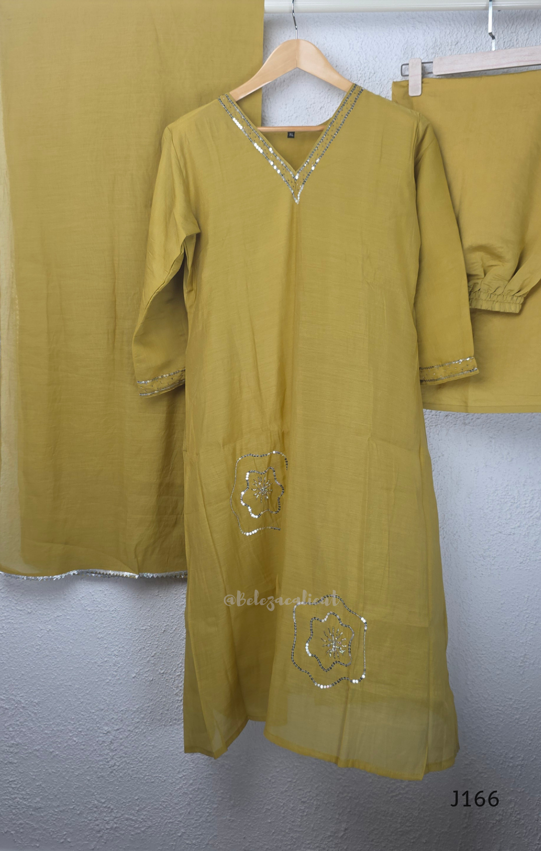 Muted mustard mul chanderi churidar suit set with silver sequin floral work, matching dupatta and bottom at Beleza Calicut.