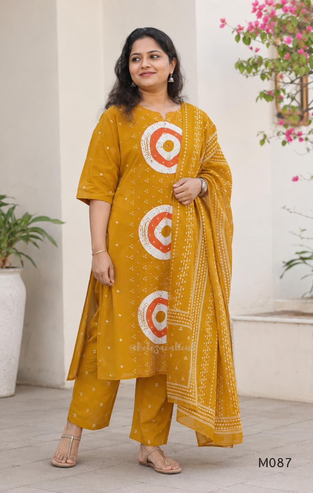 Mustard cotton 3-piece churidar set with abstract circle print kurta, matching printed dupatta and ankle-cuff bottom.