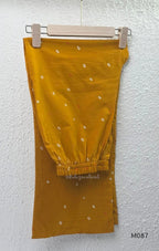 Mustard cotton 3-piece churidar set with abstract circle print kurta, matching printed dupatta and ankle-cuff bottom.