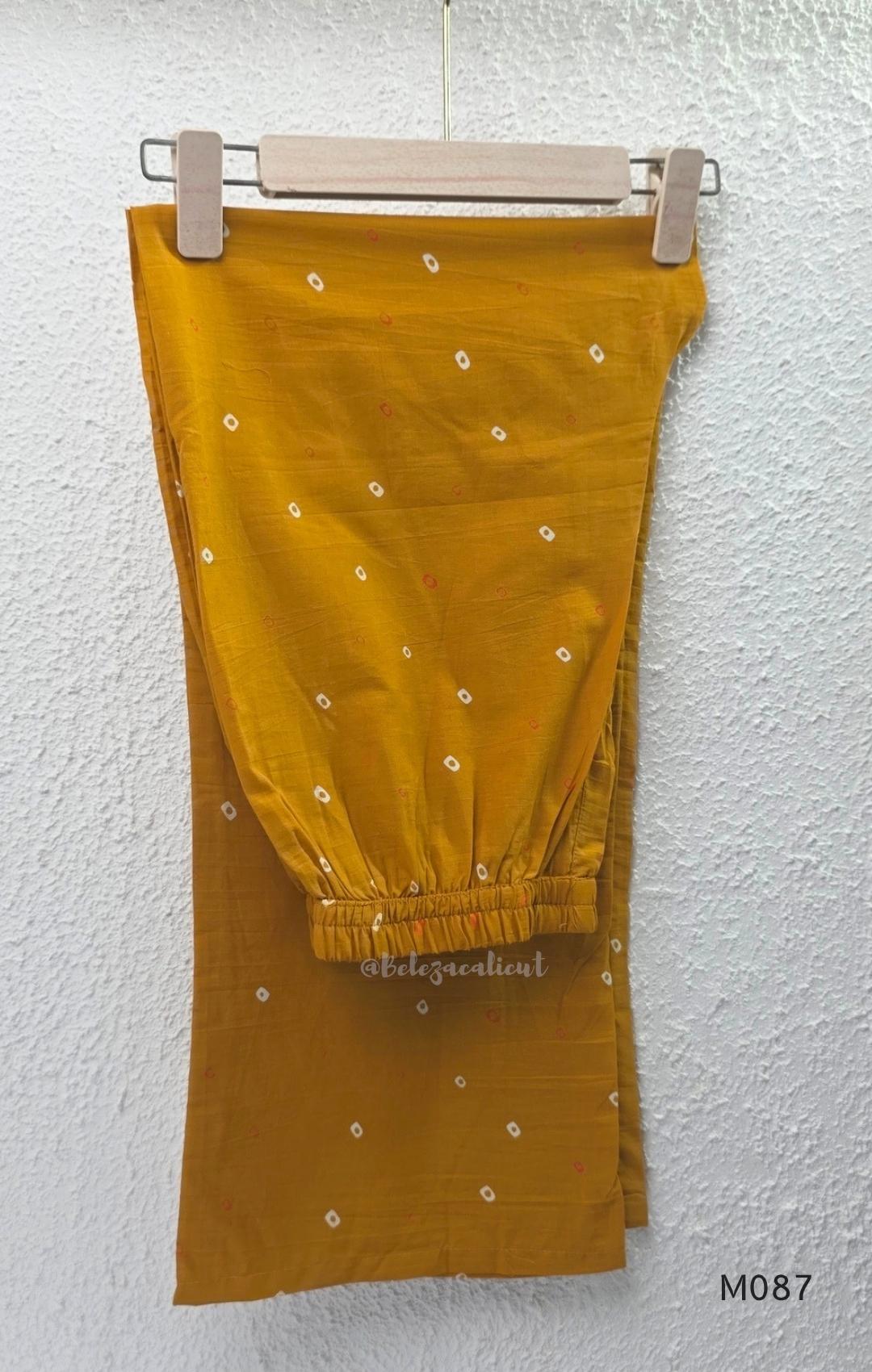 Mustard cotton 3-piece churidar set with abstract circle print kurta, matching printed dupatta and ankle-cuff bottom.