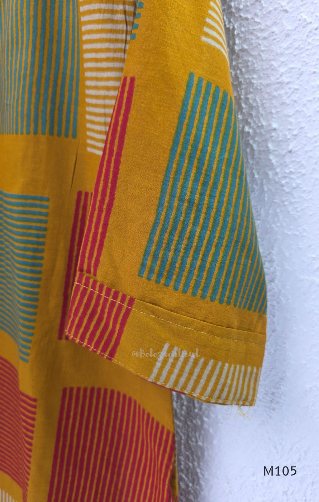 Warm mustard cotton long kurta with teal, deep pink and off-white striped rectangular motifs, V-neck and three-quarter sleeves.