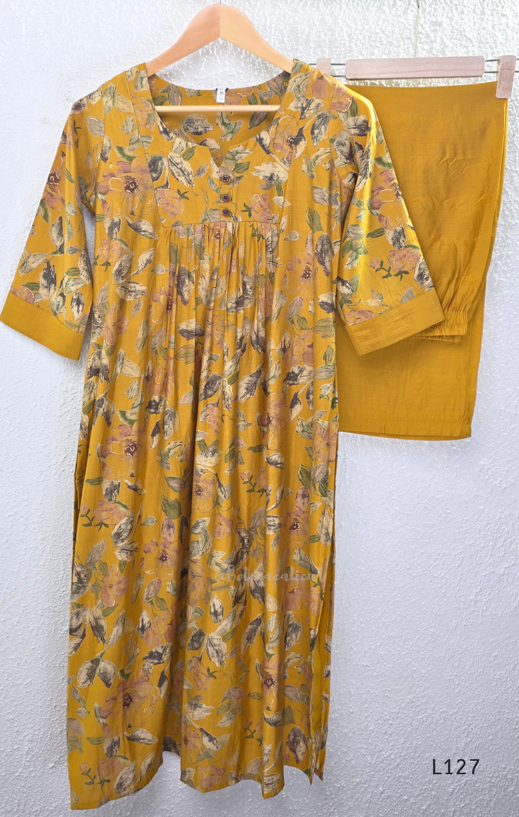 Mustard yellow silk blend 2-piece kurti set with floral print, gathered yoke, 3/4 sleeves, button detail, and matching bottom.
