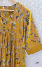 Mustard yellow silk blend 2-piece kurti set with floral print, gathered yoke, 3/4 sleeves, button detail, and matching bottom.