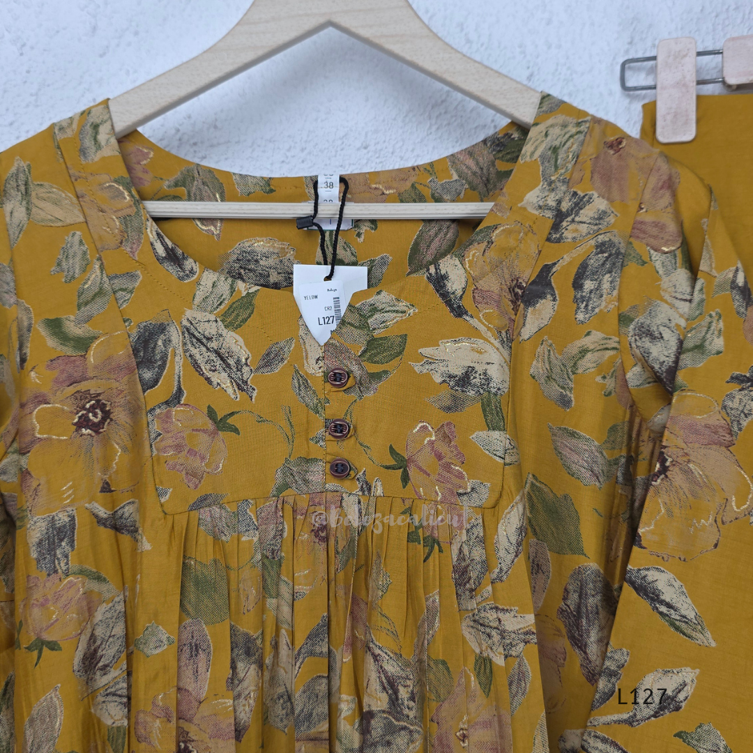 Mustard yellow silk blend 2-piece kurti set with floral print, gathered yoke, 3/4 sleeves, button detail, and matching bottom.