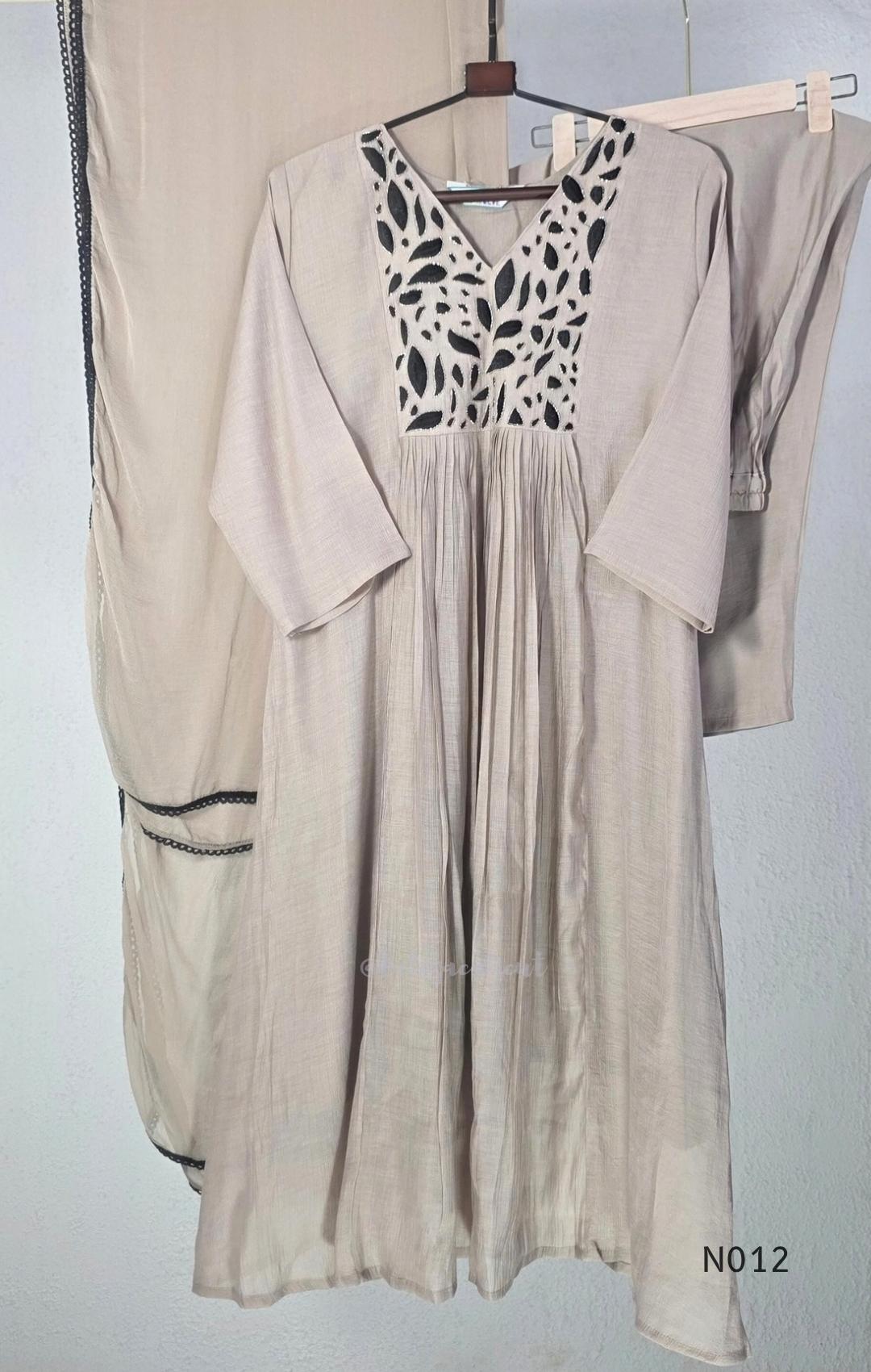 Muted ash-taupe Mul Chanderi churidar set with black leaf-pattern yoke, straight pants and matching bordered dupatta.