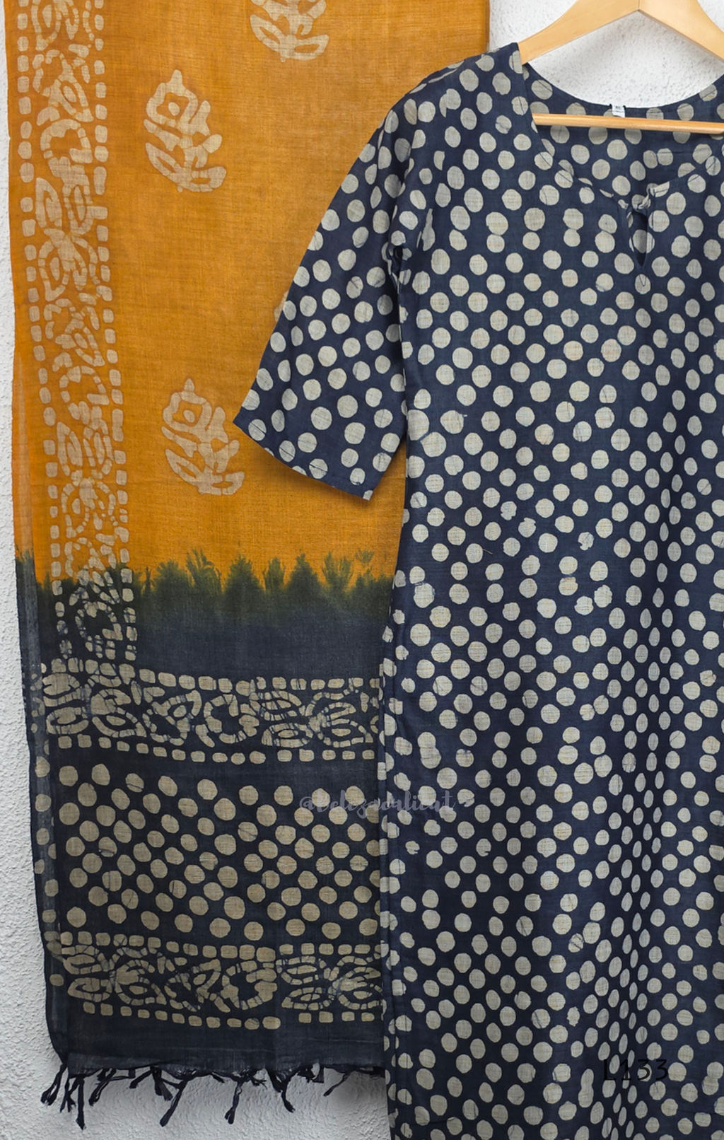Navy blue chanderi silk churidar set with all-over cream polka dot block print, straight cut kurti with round neck and 3/4 sleeves, paired with plain mustard churidar bottom and mustard-navy dual-tone block print dupatta with tassel border, Indian ethnic wear from Beleza Calicut