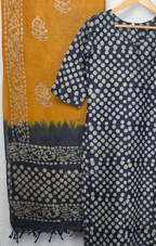 Navy blue chanderi silk churidar set with all-over cream polka dot block print, straight cut kurti with round neck and 3/4 sleeves, paired with plain mustard churidar bottom and mustard-navy dual-tone block print dupatta with tassel border, Indian ethnic wear from Beleza Calicut
