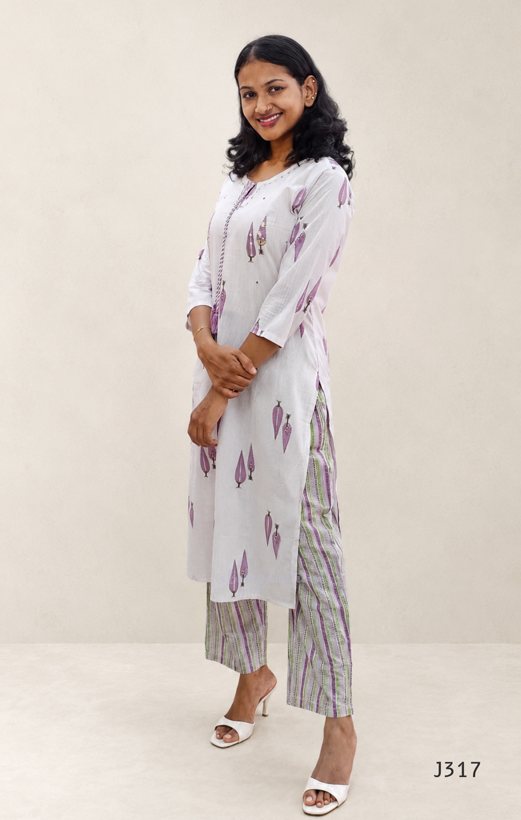 Off white cotton 2-piece kurti set with lavender leaf print, striped bottom, 3/4 sleeves, and tassel neckline worn by model.